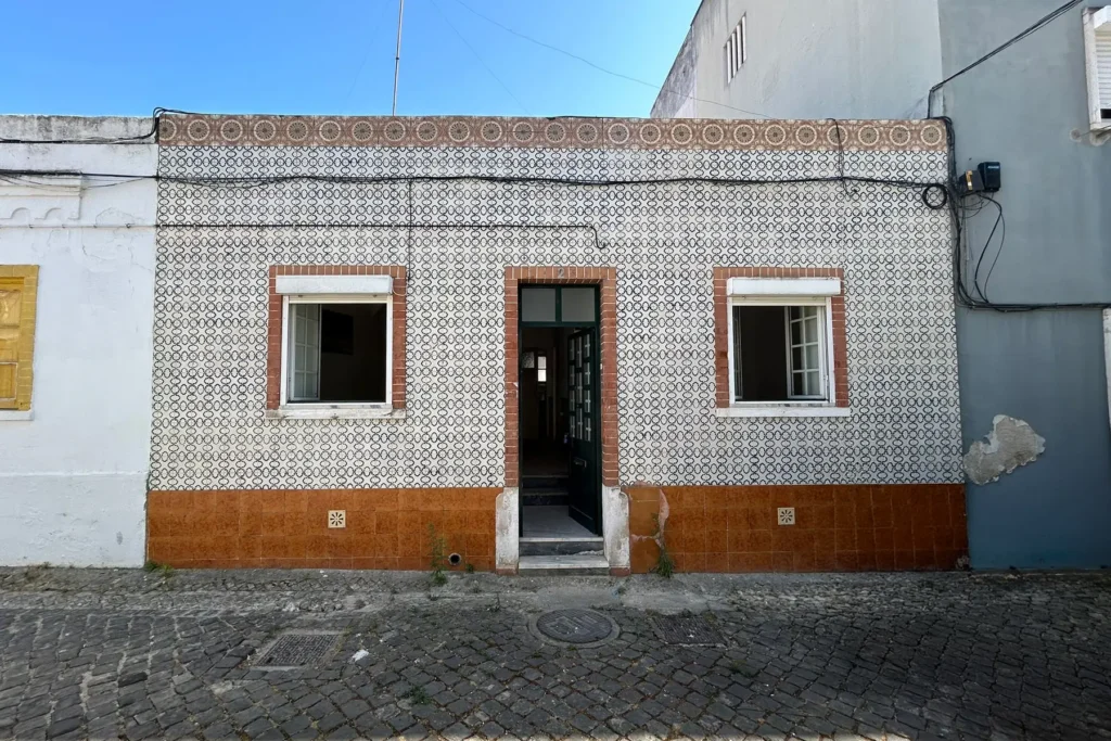 Tiled façade of a townhouse in the historic centre of Vila Franca de Xira, with a Portuguese cobblestone street